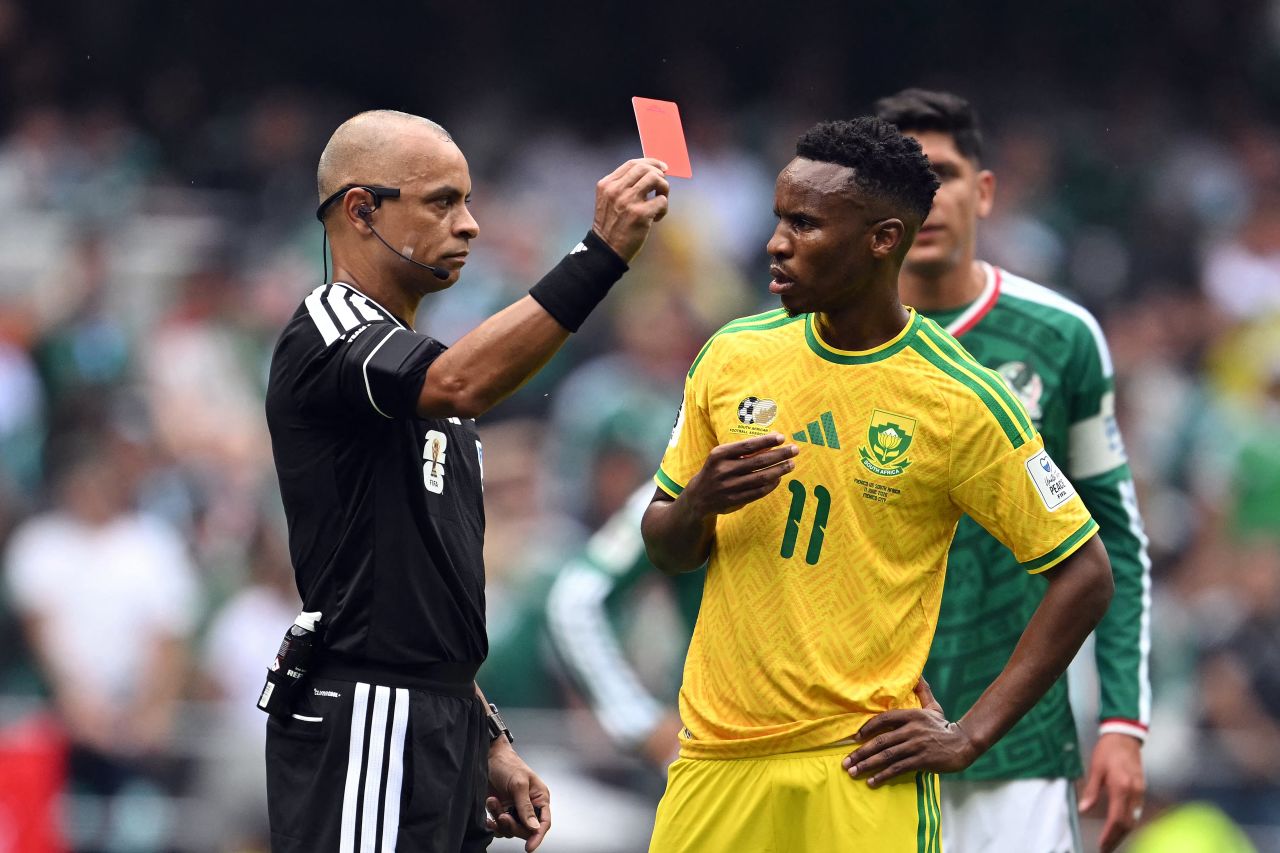 Referee Wilton Sampaio shows a red card to South Africa's Themba Zwane after video review. It was one of three red cards issued in the match.