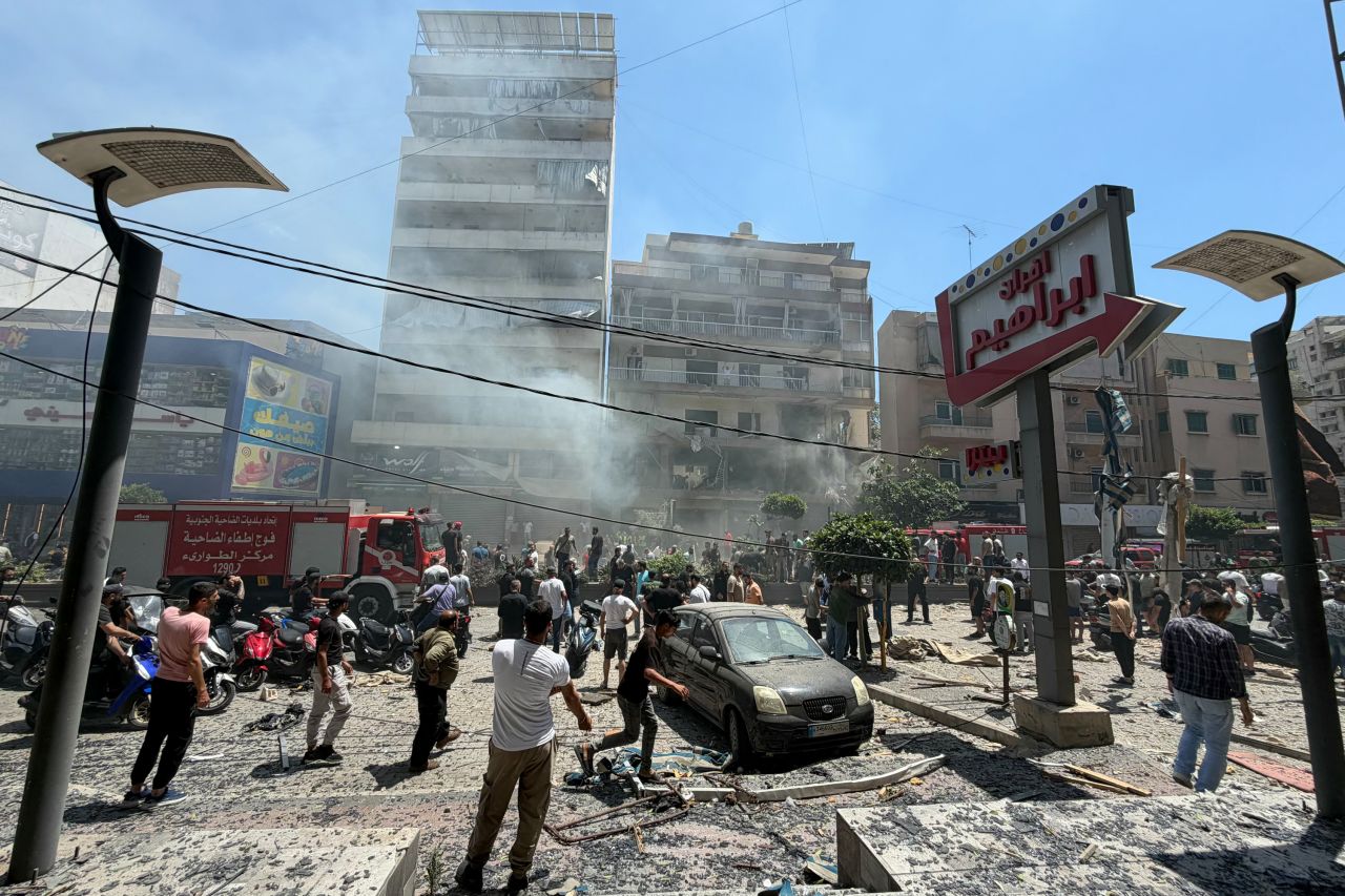 People gather at the site of an Israeli airstrike that targeted a building in Beirut's southern suburbs on Sunday.