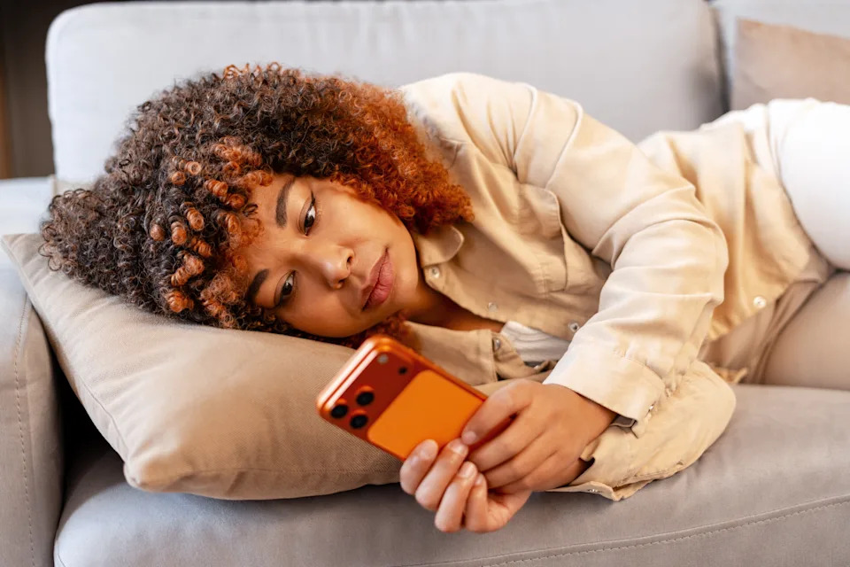 Woman scrolling health and wellness content on her phone at home