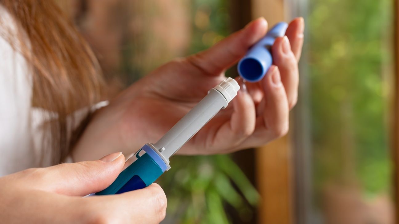 Person replacing the lid on a GLP-1 pen