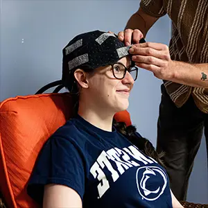 Co-authors Owen Griffith, standing, and Maddie McLaughlin demonstrate the head cooling cap used in the study. Credit: Jaydyn Isiminger / Penn State