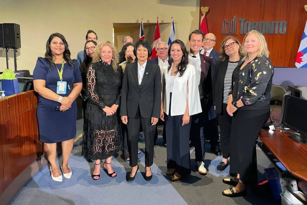 A group of people pose inside a City of Toronto office.