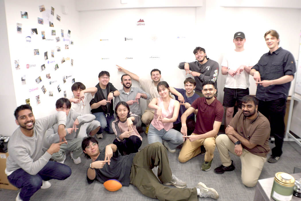 A group of young people posing on the floor of an office.