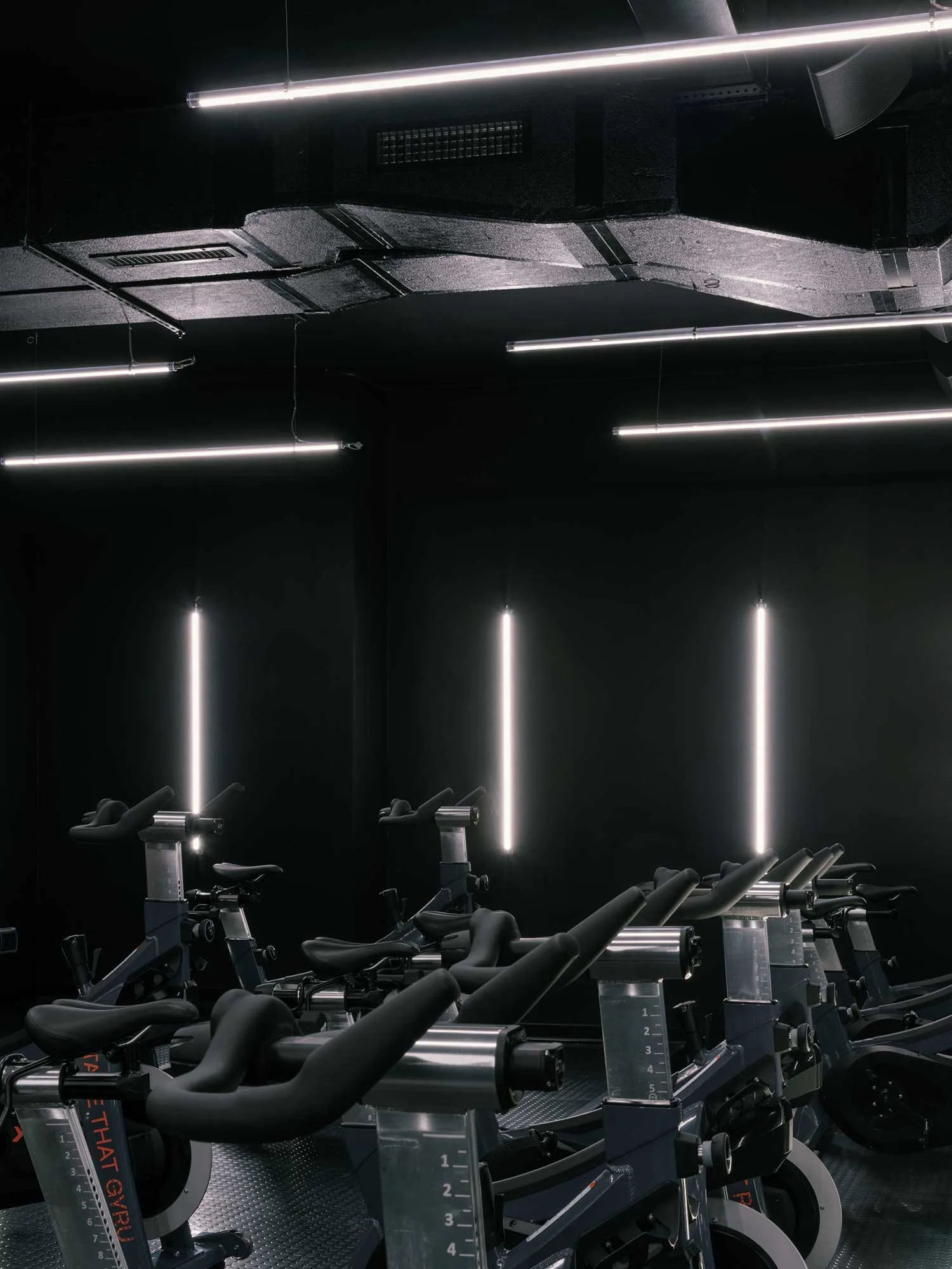 Adjustable LED bars sync with class rhythms in the cycling studio.