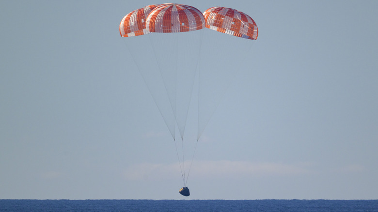 The Orion spacecraft of NASA's Artemis II mission comes in for splashdown with its parachutes deployed