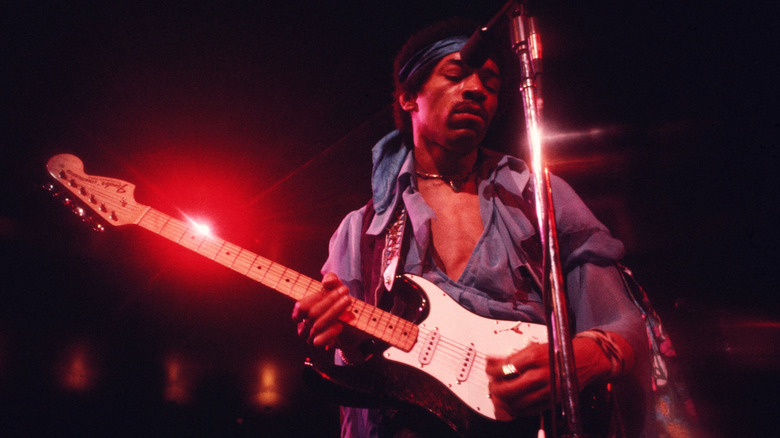 Jimi Hendrix playing guitar on stage