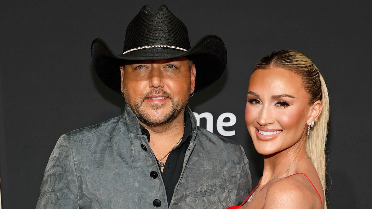 Jason Aldean and Brittany Aldean standing together at the 58th Academy of Country Music Awards in Frisco, Texas.