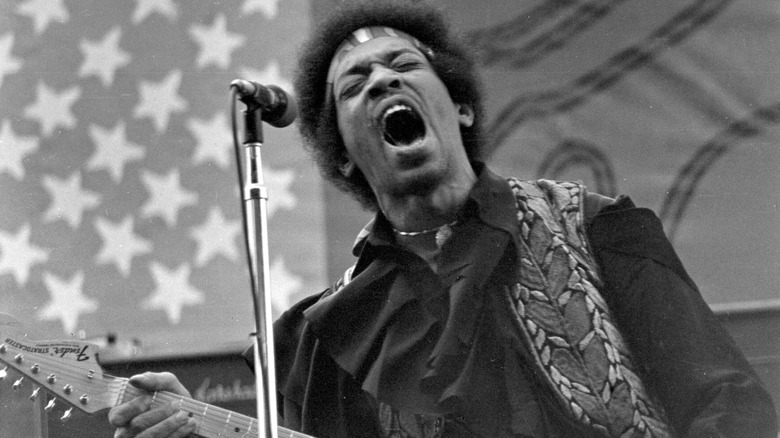 Jimi Hendrix singing with guitar on stage