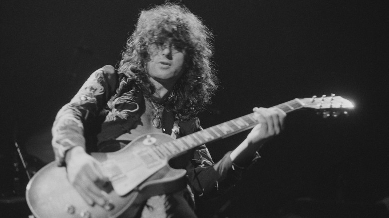 Jimmy Page performing guitar on stage