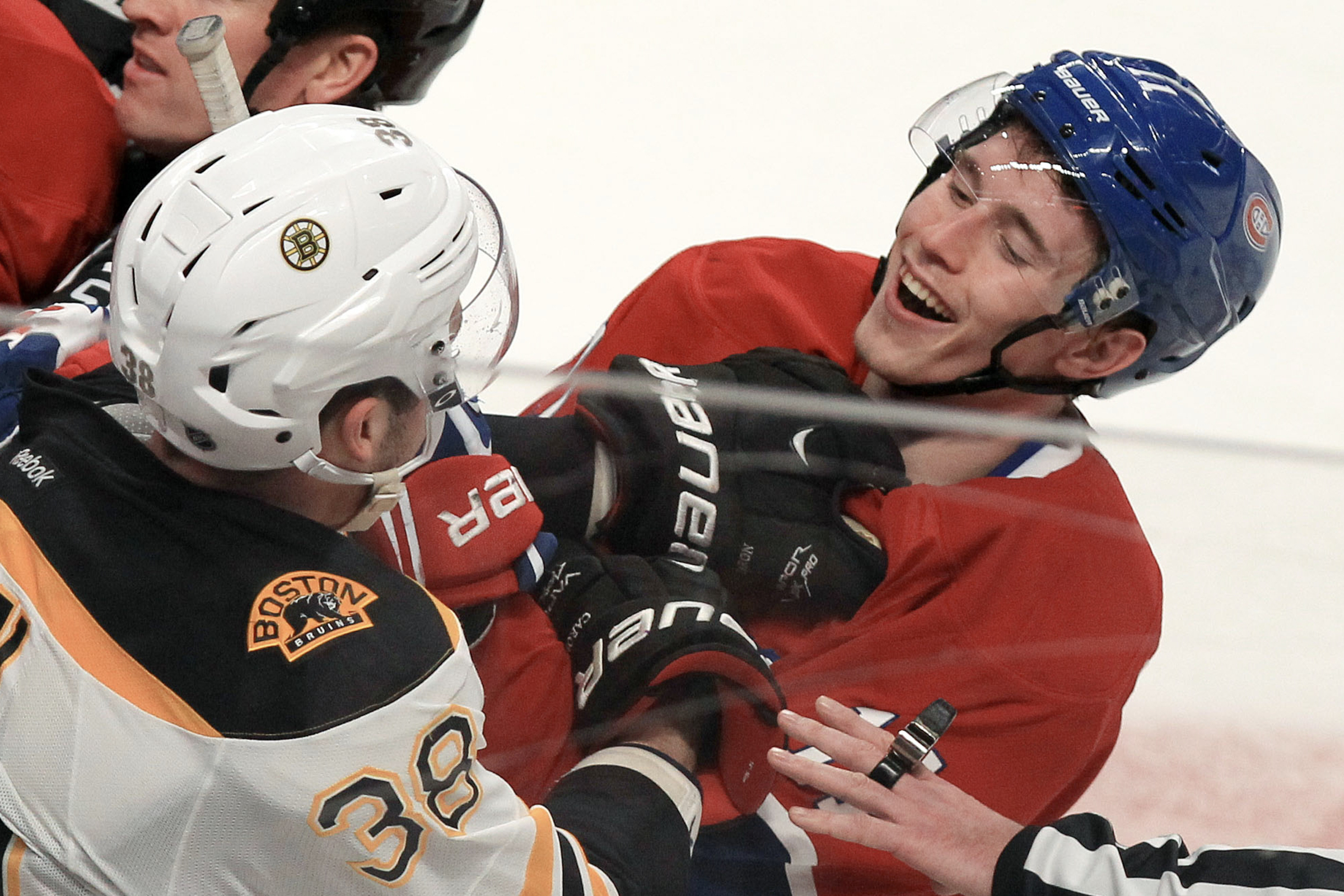 Brendan Gallagher smiles as he's in a shoving match with a Bruins player.