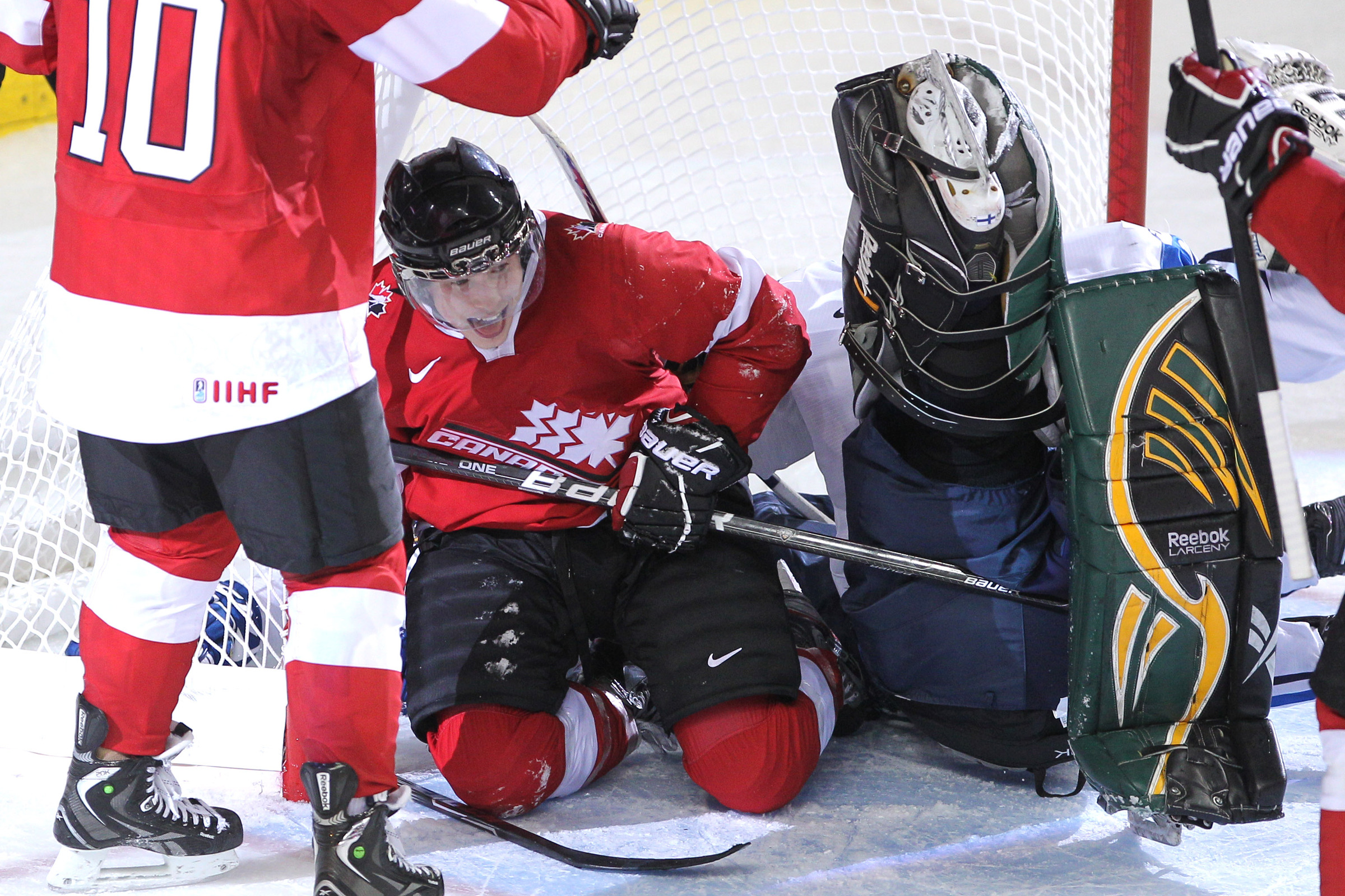 Brendan Gallagher smiles while he's in a net next to an upturned goalie.
