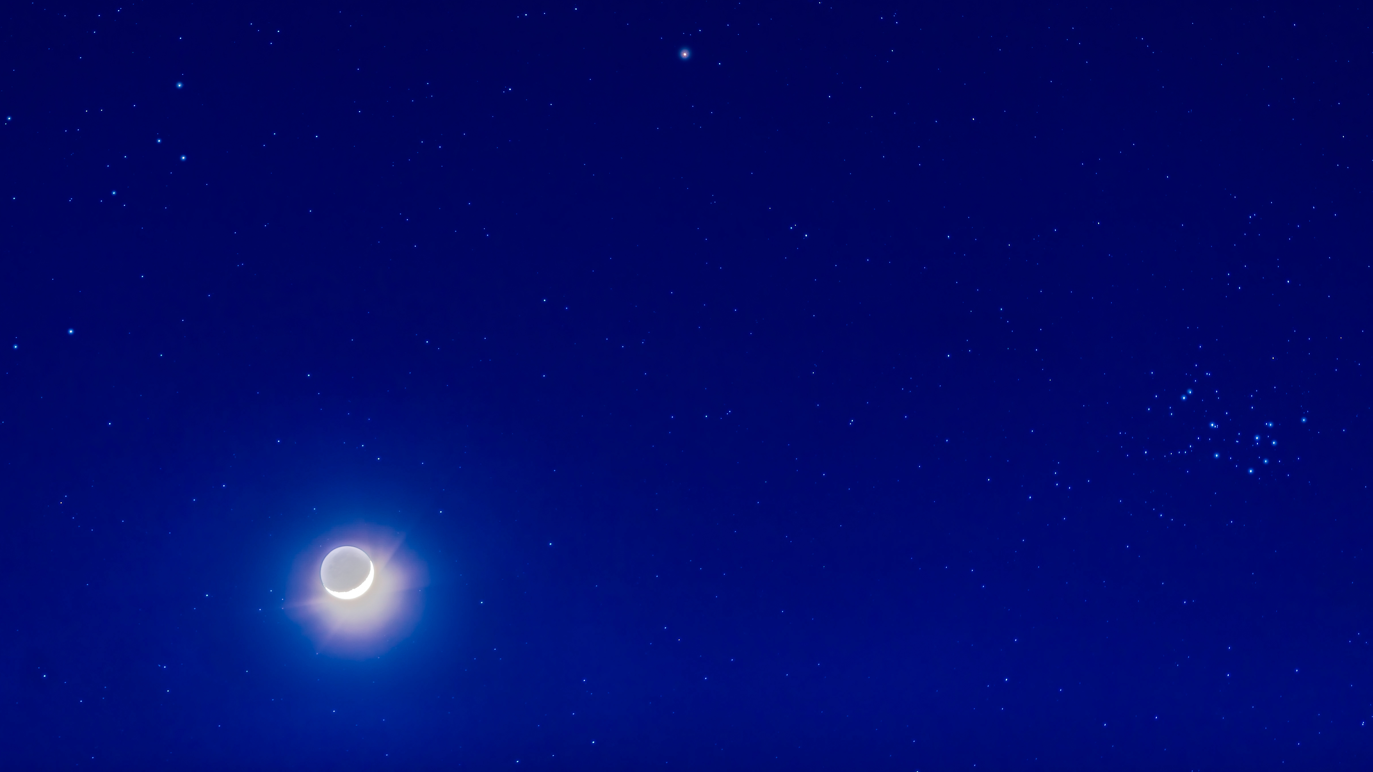 The 4-day-old waxing crescent Moon on April 8, 2019 with it below Mars (at top) and the star clusters, the Hyades (at left, with reddish Aldebaran) and Pleiades (at right) in Taurus, and set into the deep blue evening twilight. This is with the 135mm Canon telephoto at f/2.8 with the Canon 6D at ISO 400, in a blend of 7 exposures from 1/4 second to 8 seconds, blended with luminosity masks from ADP Pro3 extension panel in Photoshop, to prevent the Moon from being too overexposed while retaining the stars and blue sky. The camera was tracking the sky. I added an Orton effect glow to the stars for artistic effect, with a star mask to limit the glows to just the stars. I really needed a 105mm lens for this, as the framing is pretty tight! (Photo by: Alan Dyer/VW PICS/Universal Images Group via Getty Images)