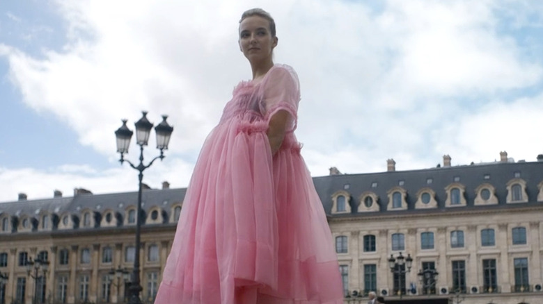 Jodie Comer as Villanelle wearing a pink dress in 