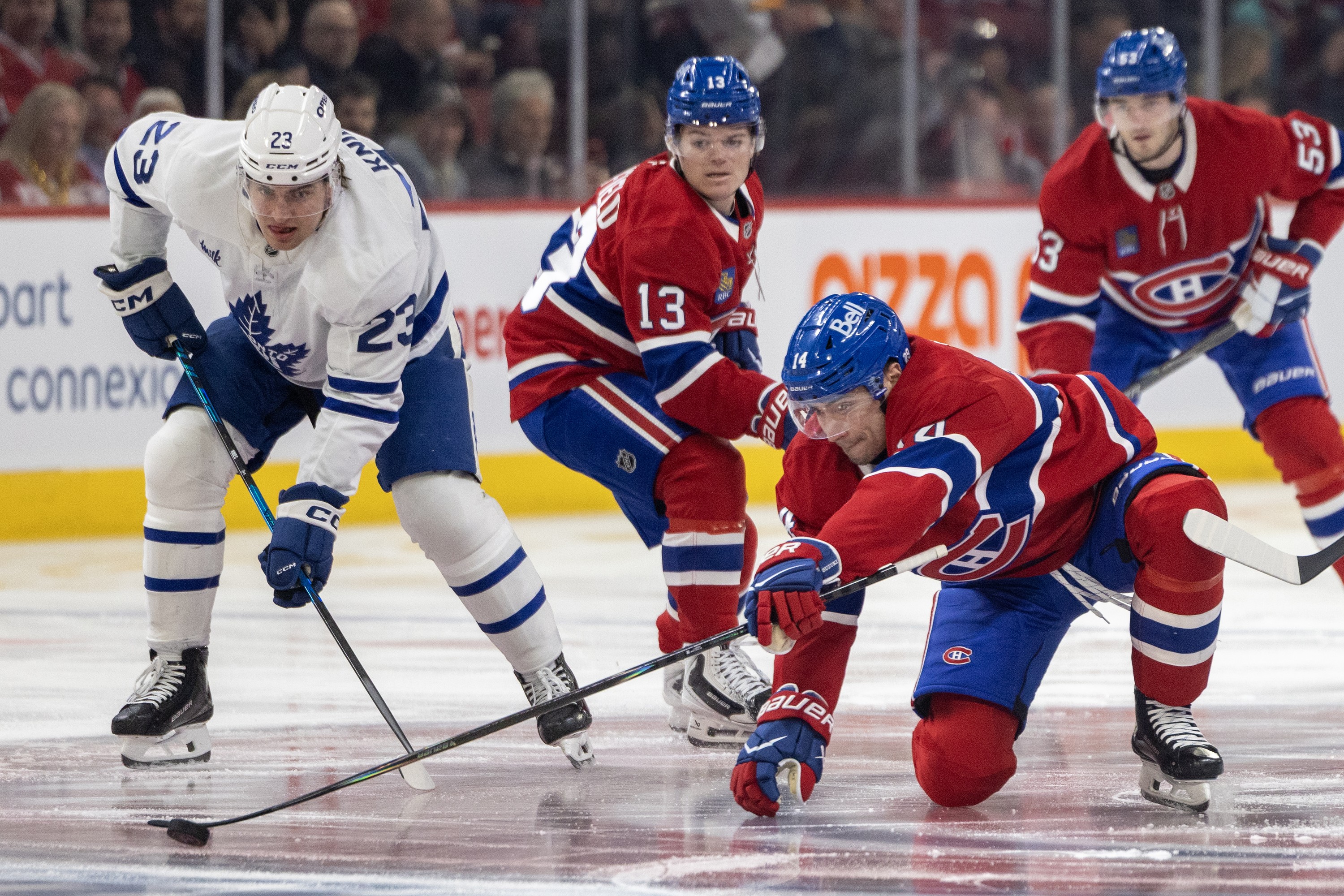 Canadiens captain Nick Suzuki stretches for the puck as Toronto Maple Leafs' Matthew Knies and Habs' Cole Caufield and Noah Dobson, right, look on during first period in Montreal on March 10.