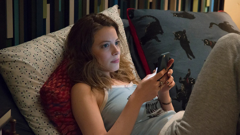 Mickey on her phone in bed