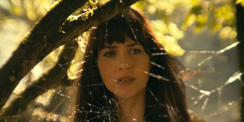 Dakota Johnson standing behind a spider web in Madame Web