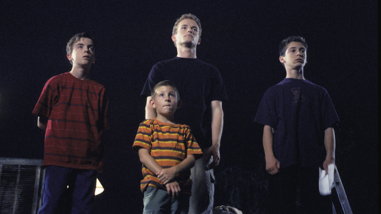 Malcolm, Francis, Dewey, and Reese stand solemnly in the dark
