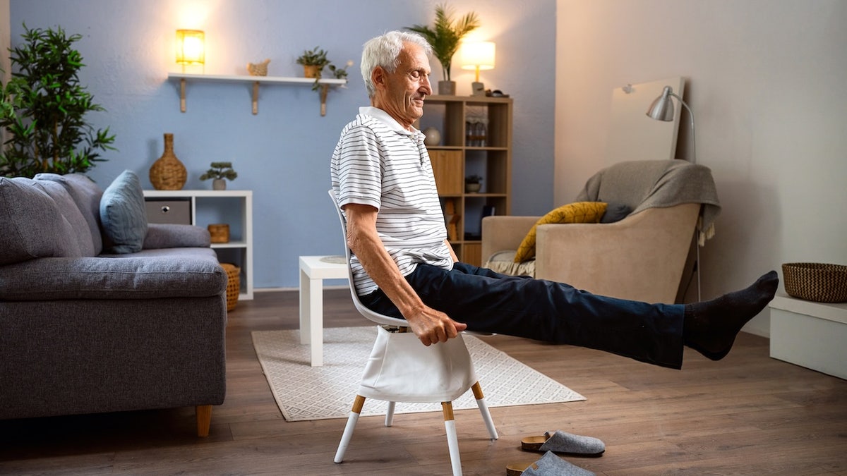 Senior man exercising at home indoors