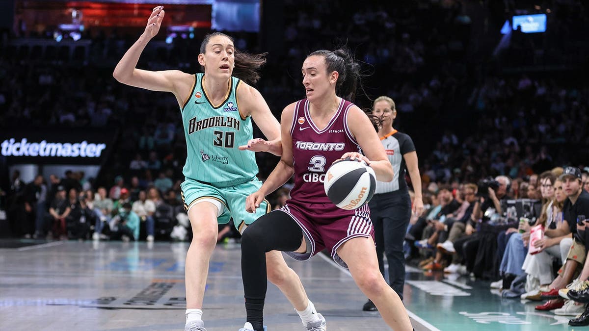Marina Mabrey driving past Breanna Stewart during basketball game at Barclays Center