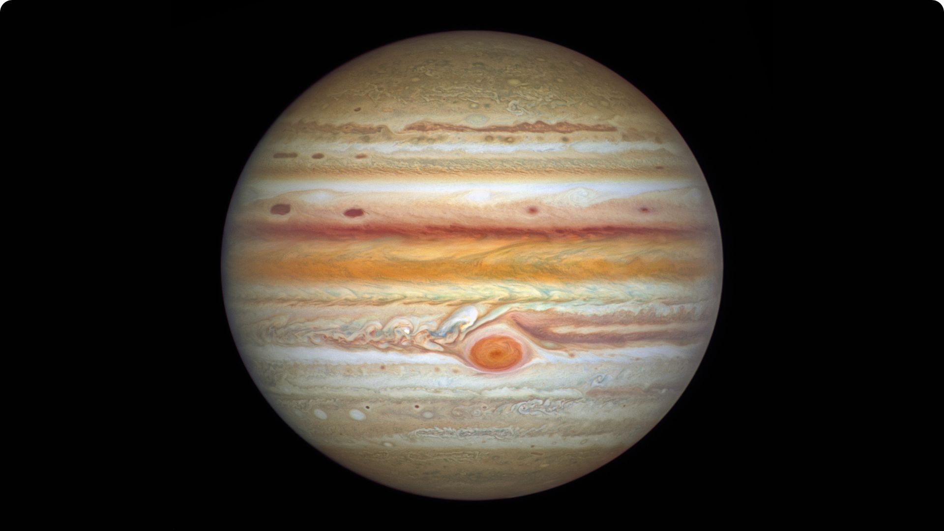 The gas giant Jupiter is pictured against a black background in an image captured by the Hubble Space Telescope.