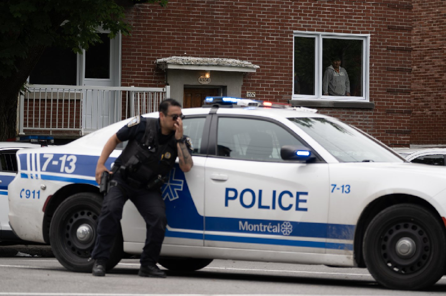 A person looks out of a window as police respond to a shooting in the Côte-des-Neiges district of Montreal on Monday, June 22, 2026.