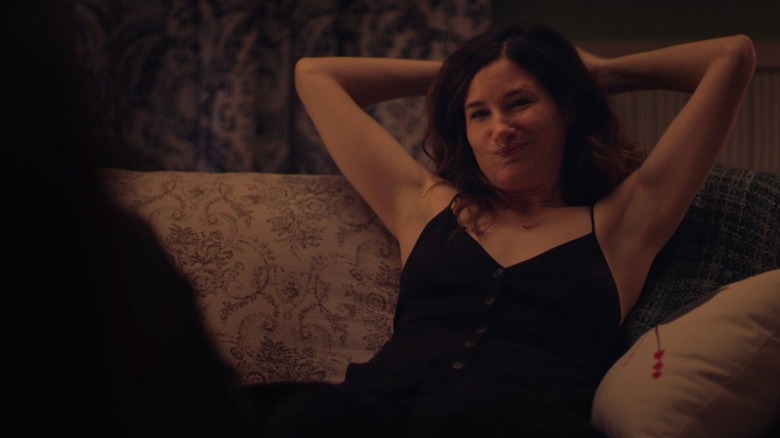 Eve smiling while leaning back on a couch