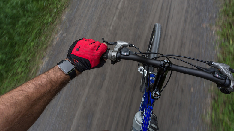 Man wearing a 42mm Stainless Steel Apple Watch with black Bracelet on a bicycle