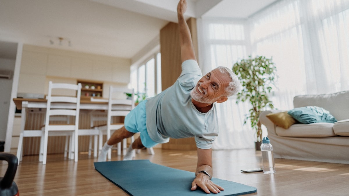 Senior man doing yoga exercise at home