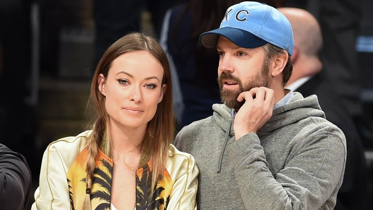 Actress Olivia Wilde and actor Jason Sudeikis standing together at the NBA All-Star Game in Toronto