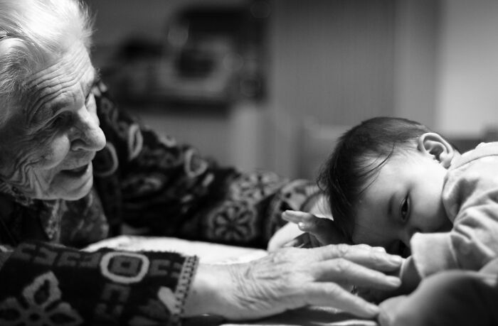 Black and white photo of elderly woman with a baby, symbolizing intergenerational dementia care