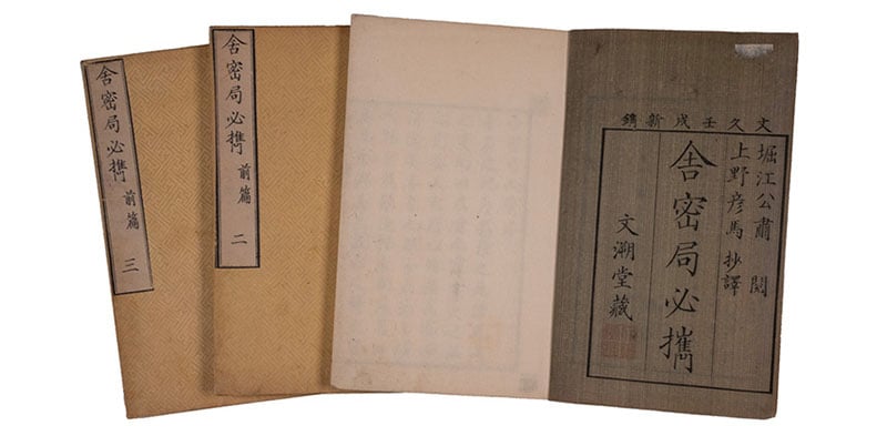 Four vintage Japanese books with textured and plain covers, arranged partially overlapping. The covers display vertical black Japanese characters, and one book has a grayish cover with a bordered title area.