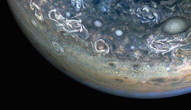 Three quarters of Jupiter can be seen in this photo; the darkness of space covers the bottom of the image. Green and blue swirls cover the planet's surface.