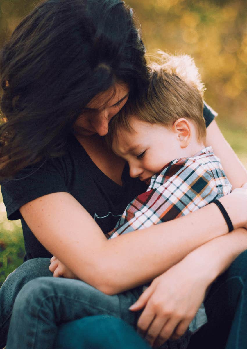protective mom hugging her son close