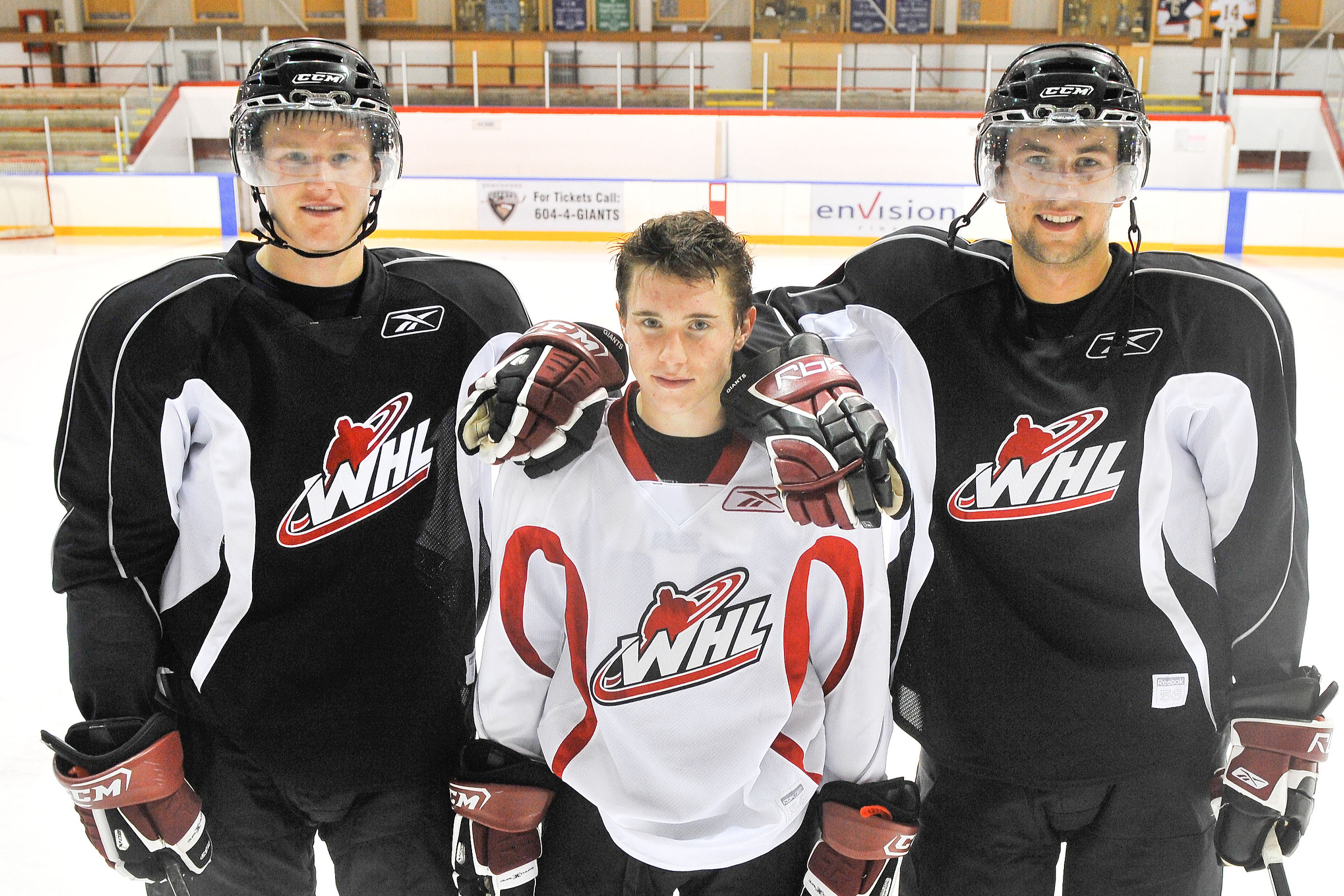 Brendan Gallagher poses for a photo on the ice between two much taller players.