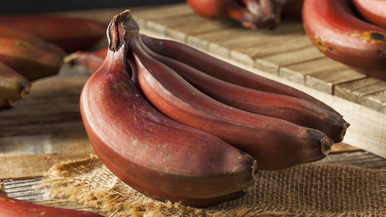 Red bananas on a burlap mat.