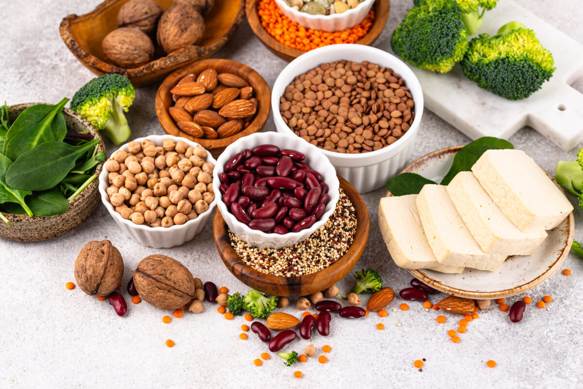 Photo shows a selection of plant-based proteins, including beans, tofu, nuts, and legumes