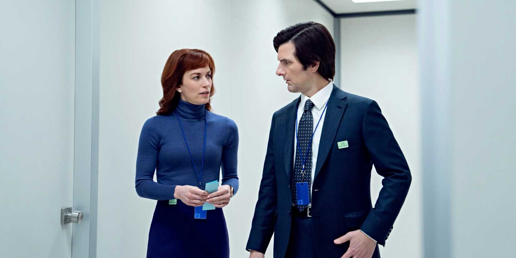 Britt Lower and Adam Scott talk in an office hallway in Severance