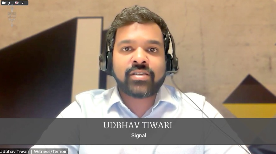 Man with headset speaking in a video call; caption shows 'UDHBHAV TIWARI' and 'Signal'
