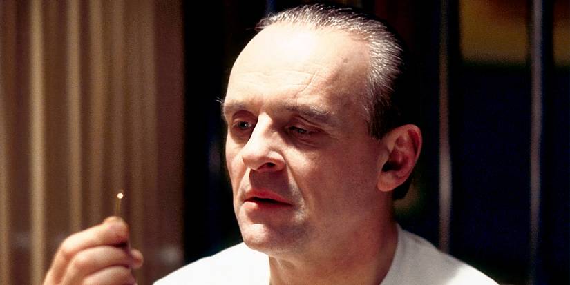 Anthony Hopkins staring intently at a small metal object in The Silence of the Lambs.