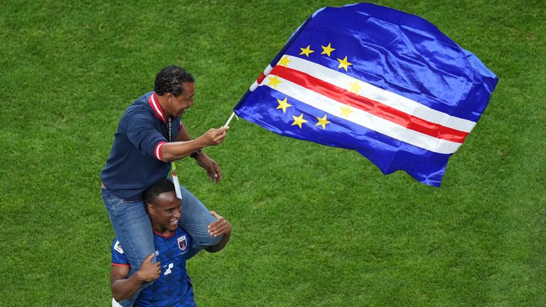 Cape Verde head coach Bubista waves a flag while being carried on the shoulder of Jovane Cabral