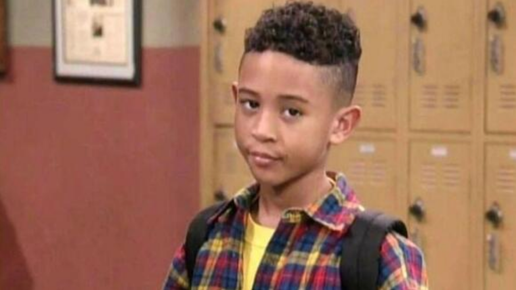Tahj Mowry as T.J. Henderson smirking in front of school lockers in Smart Guy.