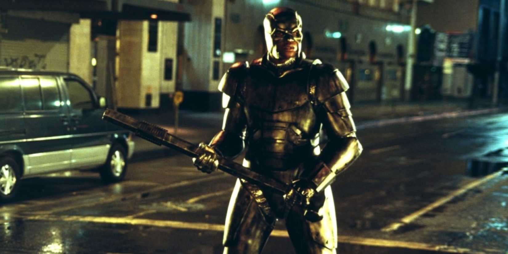 Steel standing on the street holding a metal rod in Steel