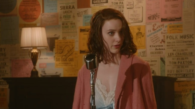 Midge wearing a pink coat on stage