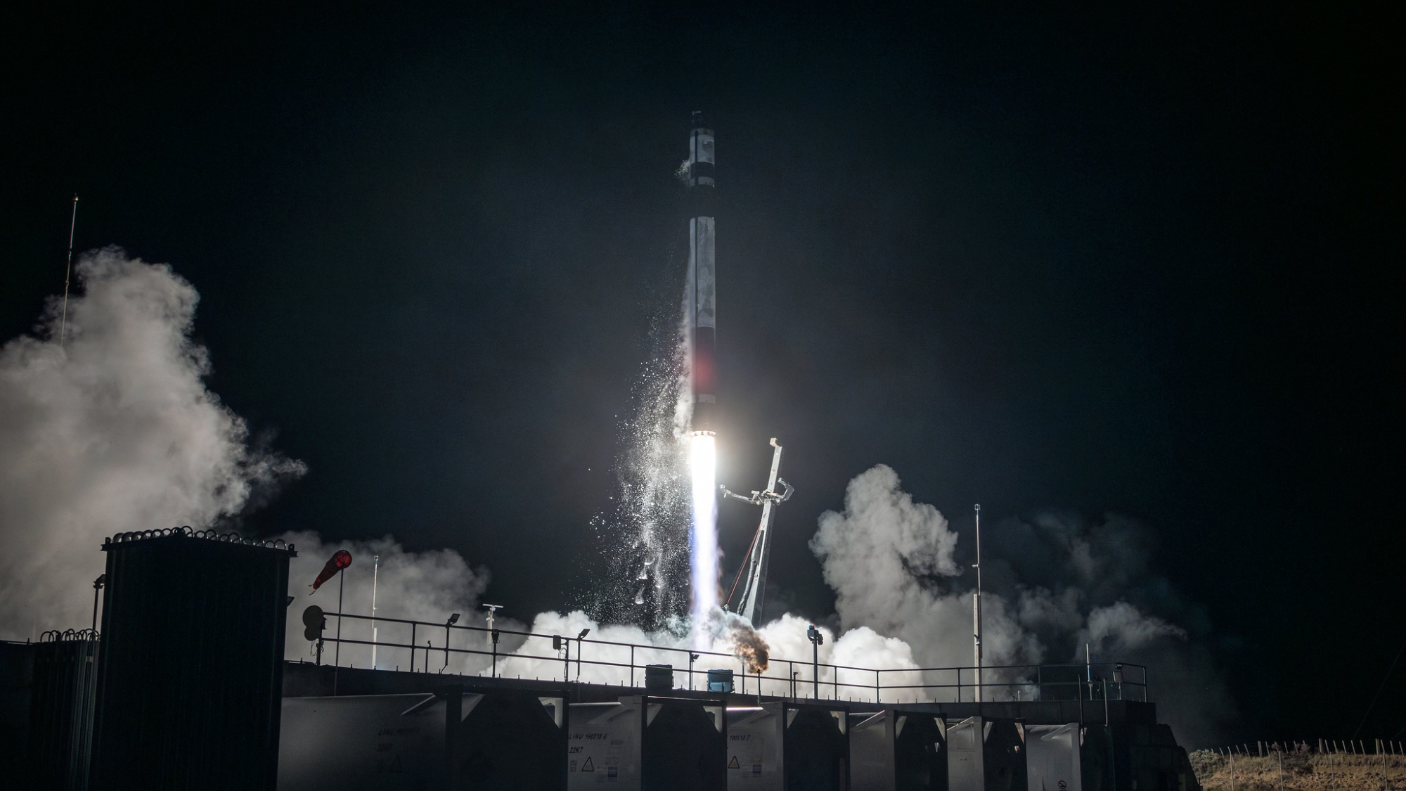 a black and white rocket launches into a dark night sky