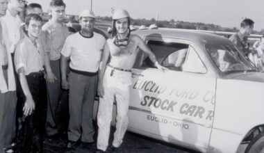 Group of men posing beside a vintage stock car with Euclid, Ohio lettering on the door.
