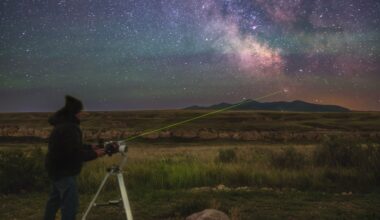 a man stands shining a laser to messier 7 which is in the tail of the scorpius constellation.
