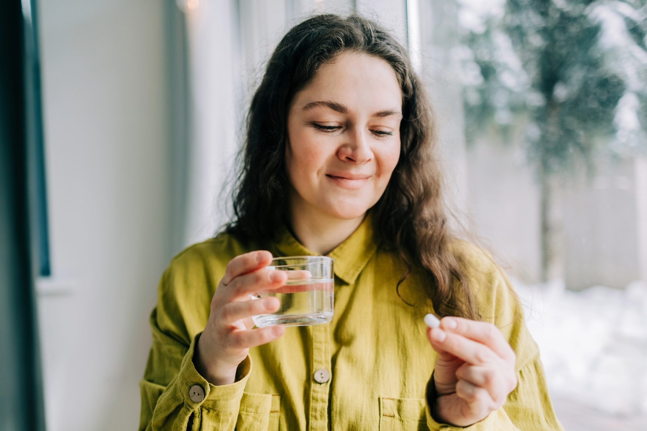 Woman with multivitamin pill.