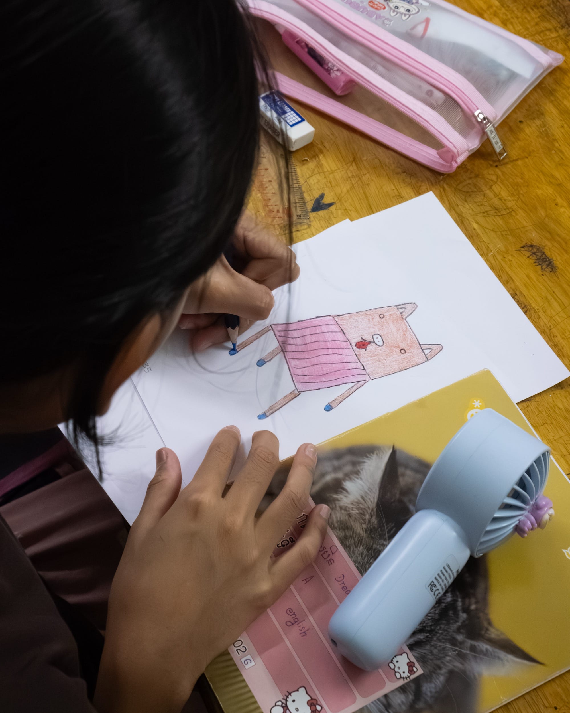 a child draws a whimsical chair design with colored pencils