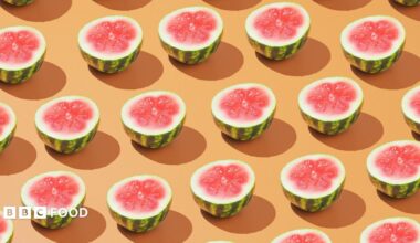 Rows of halved watermelons on a pale orange background