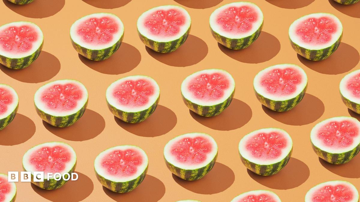 Rows of halved watermelons on a pale orange background
